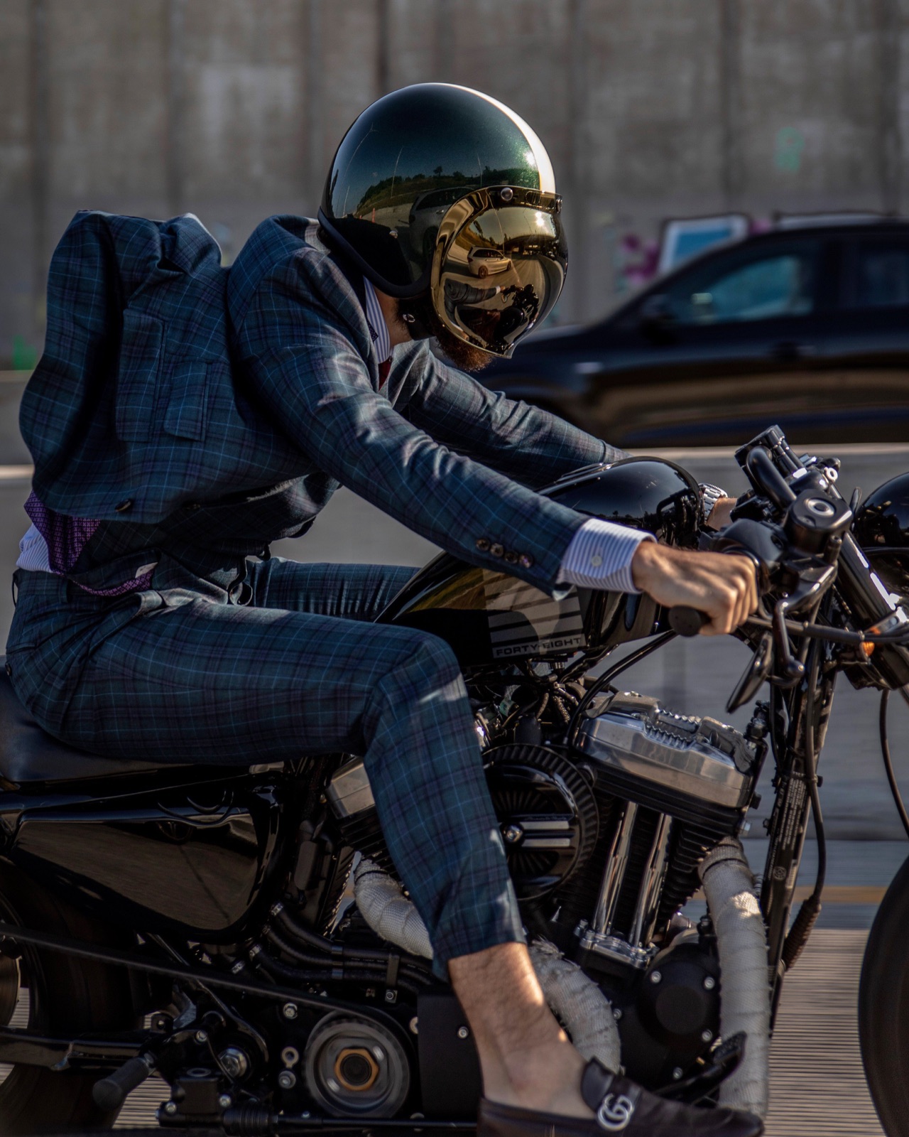 A MigsWax client in a made to measure plaid suit, riding a motorcycle