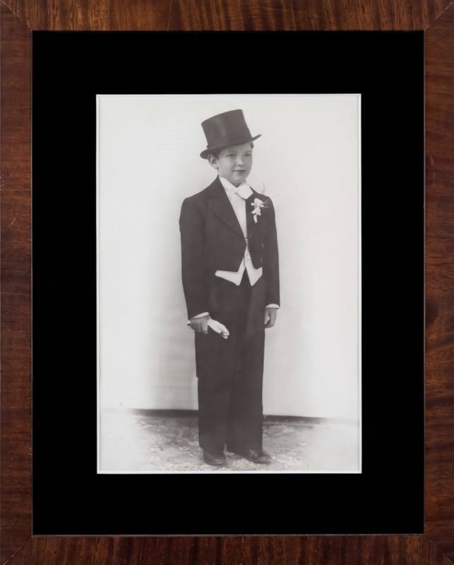 Framed portrait, a boy of the house in top hat and tails