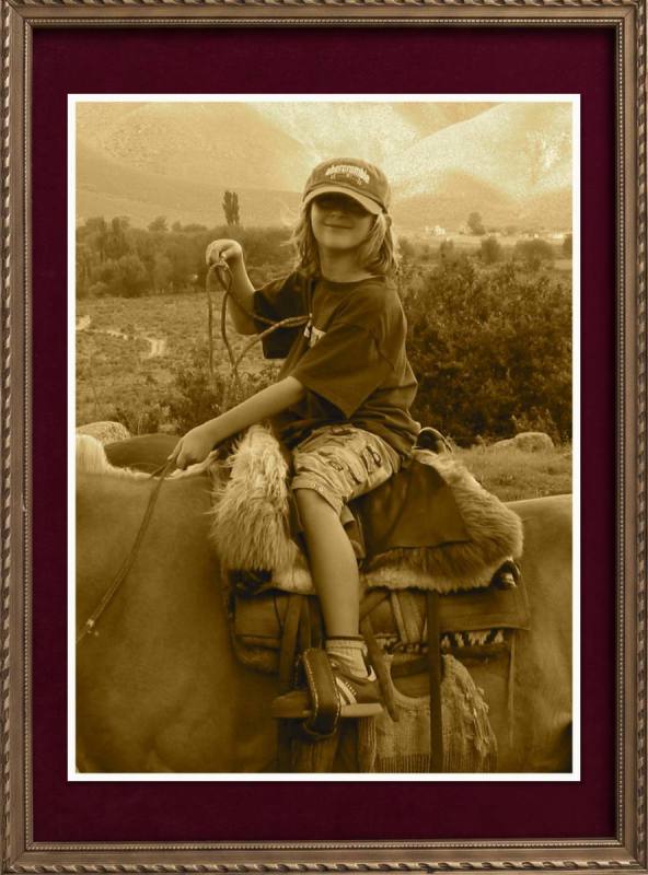 Framed sepia photo, a young boy riding a horse