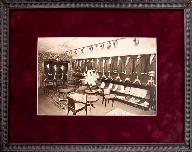 Framed photograph, the rental floor lined with tuxedos